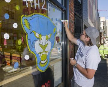 student painting a window